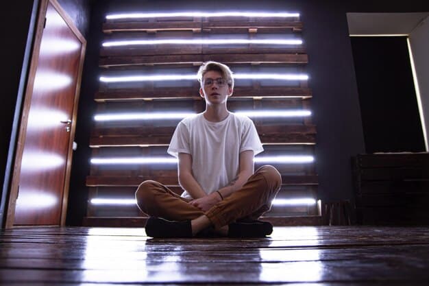 A person sitting cross-legged in a quiet room, meditating with their eyes closed and a peaceful expression. The room is dimly lit with soft, natural light, creating a calming atmosphere.