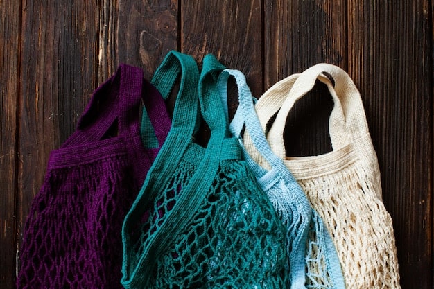 A variety of colourful shopping bags repurposed from old t-shirts, displayed in a market setting. The bags feature different designs and patterns, showcasing the creative potential of upcycling textiles.