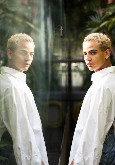 A person looking at their reflection in a mirror, but the reflection shows a distorted and negative image of themselves. This reflects the internal self-doubt and negative self-perception associated with imposter syndrome.