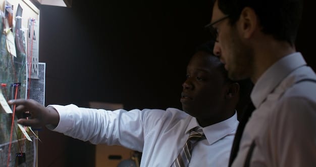 A diverse team collaborates around a large interactive display showing a complex network graph, representing data connections and relationships. The atmosphere is collaborative and innovative.