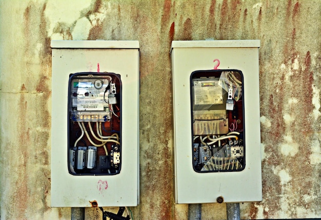 A shot of an old, outdated electrical panel with corroded wiring, contrasted with a modern, updated panel with clean wiring.