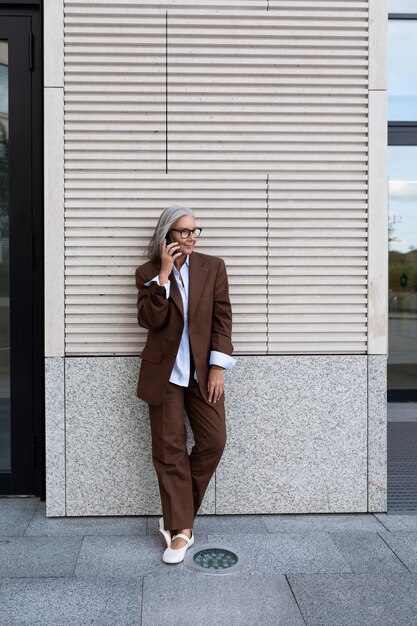 A full-body shot of a model confidently wearing a chic and professional ensemble sourced entirely from Shein, featuring tailored trousers and a fitted blouse, against an urban backdrop.