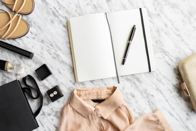 A flat lay display of a minimalist capsule wardrobe for work, featuring black trousers, a white blouse, a gray cardigan, and simple accessories.