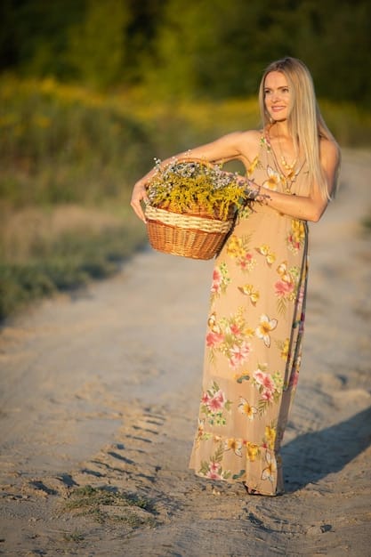A woman in a vibrant floral maxi dress with a flowing skirt, walking through a sunlit garden, holding a small wicker basket and wearing delicate sandals.