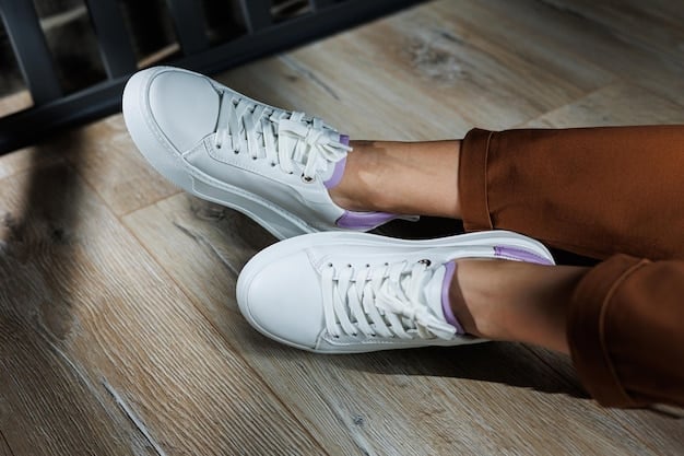 A close-up shot of a pair of stylish, branded athleisure sneakers, featuring a chunky sole and a mix of neutral tones with metallic accents, paired with ribbed ankle socks and sleek, black Shein leggings on a model walking on a city street.