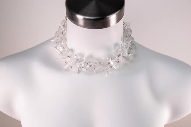 A close-up shot of a minimalist necklace made from recycled silver, elegantly styled on a mannequin against a soft, naturally lit background, emphasizing conscious fashion.