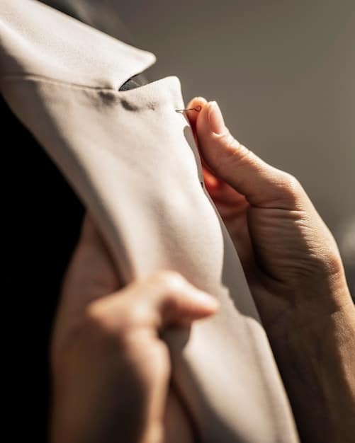 A close-up of a woman's hand adjusting the sleeve of a Shein sustainable shirt, showing off the fabric texture and ethical brand tag, with a blurred background of a minimalist wardrobe.