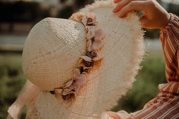 A close-up shot of hands delicately adjusting a straw hat adorned with dried flowers on a model wearing a Shein cottagecore dress, showcasing intricate lace details on the sleeves.