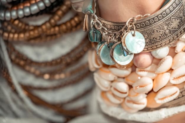 A detailed shot of layered bohemian jewelry, including beaded necklaces, a turquoise pendant, and silver bangles, resting on a white crochet top.