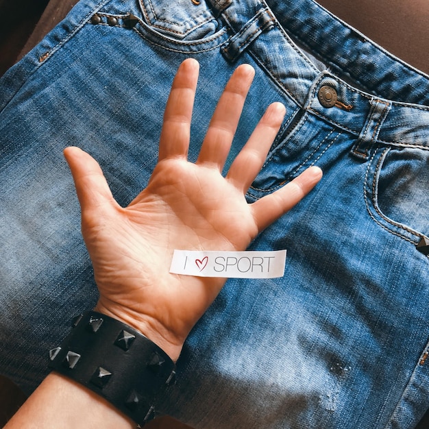 A close-up of a care label inside a garment, with universally recognized laundry symbols, held by a person's hand.