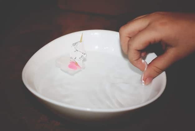 A person gently cleaning a Shein pendant necklace with a soft, white microfiber cloth, a small bowl of mild soapy water in the background.