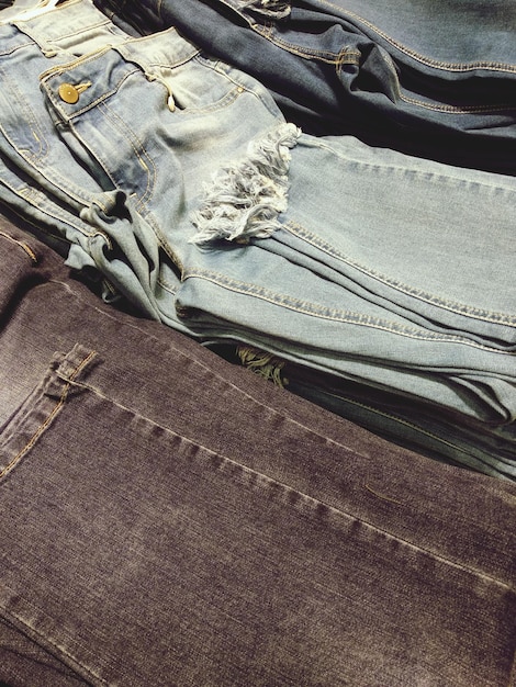 A detailed flat lay of various Shein plus-size jeans in different washes (dark, mid, light) and distressed finishes, showcasing the variety of textures and styles.
